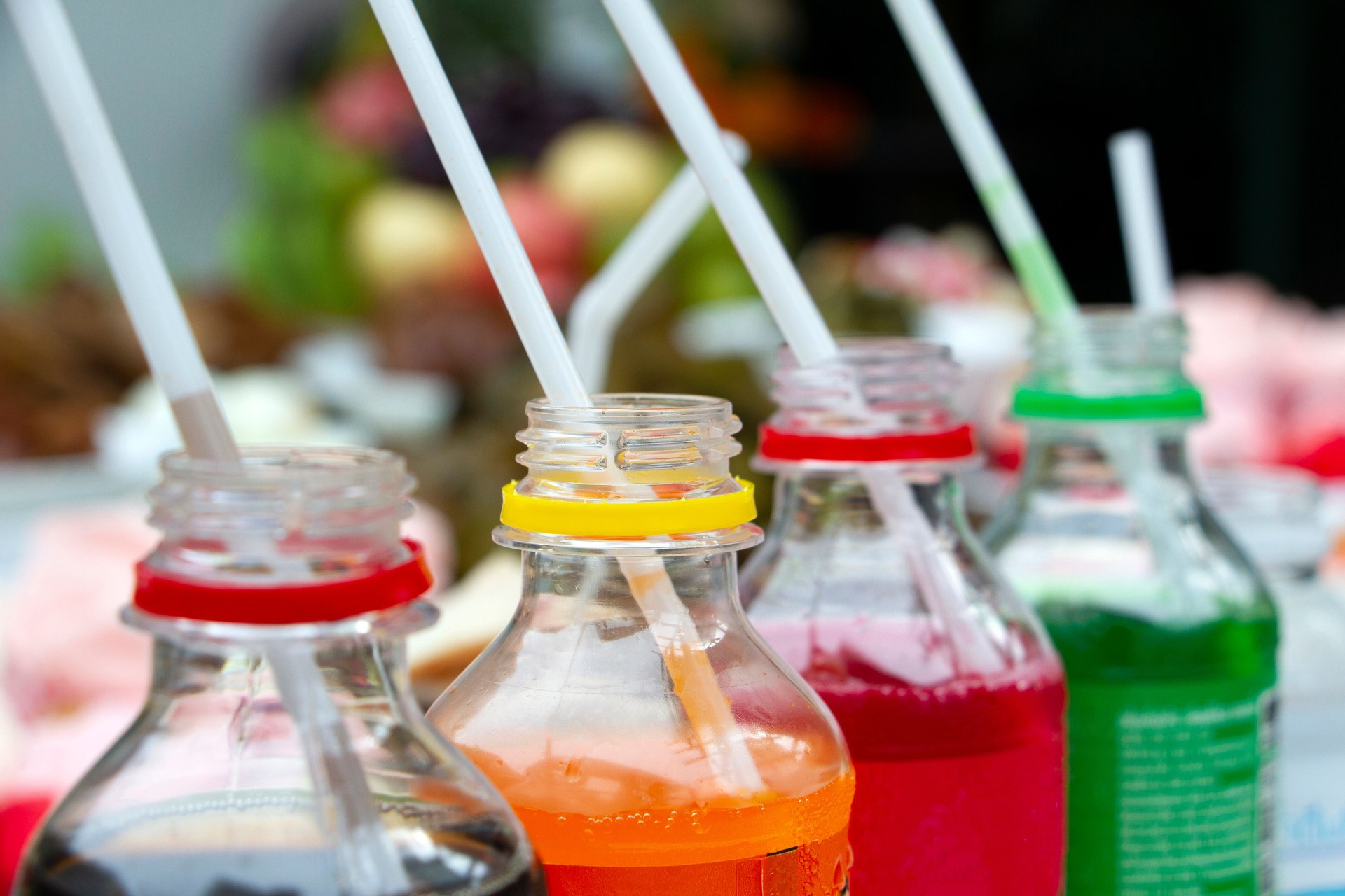 Colorful of carbonated soft drink pop soda bottles with plastic straw.